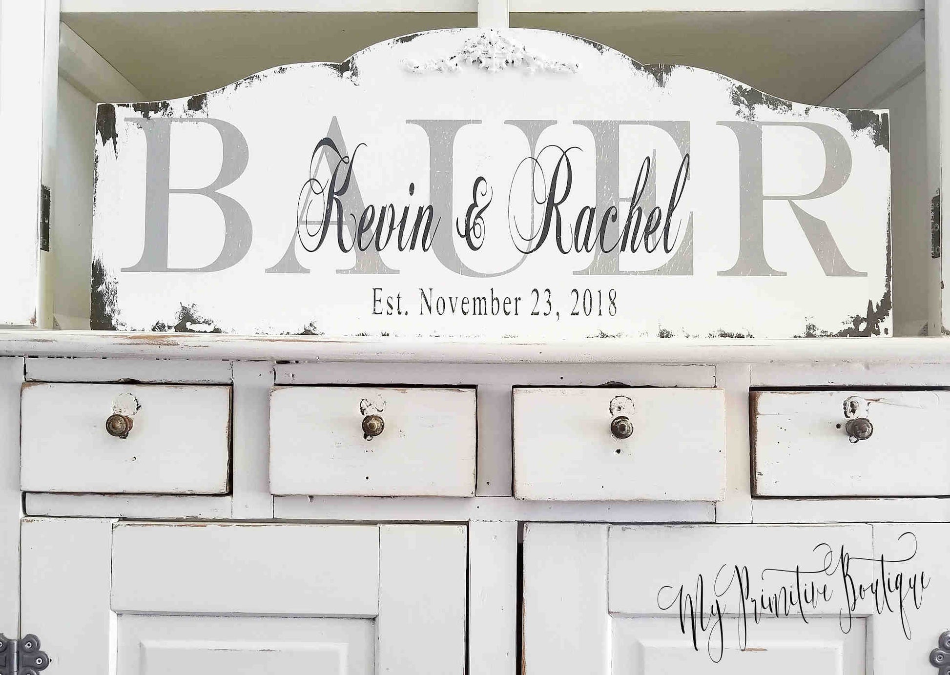 Established family name sign distressed ivory finish with black lettering.